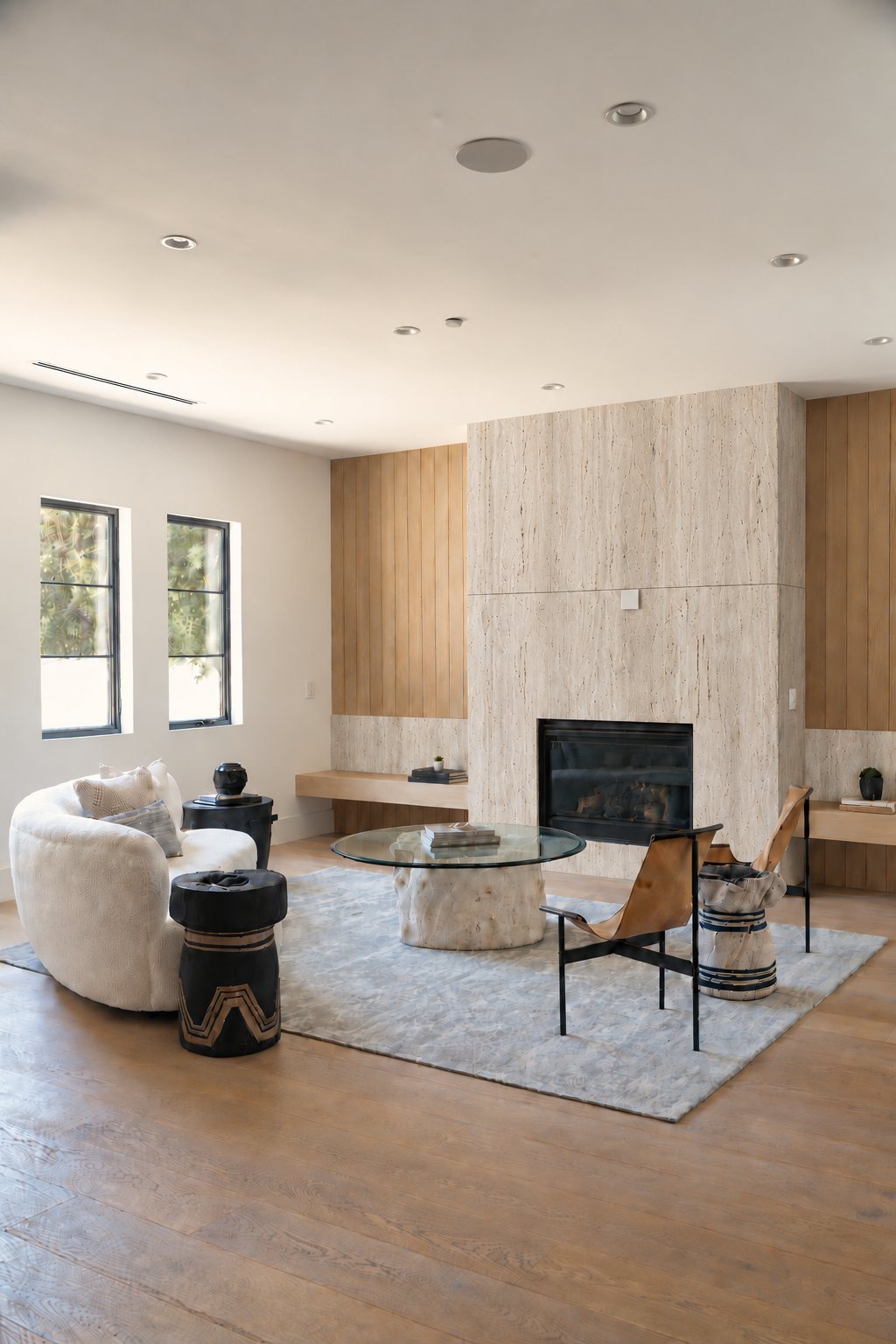 Full home remodel in Newport Beach: travertine fireplace wall, white oak panelling and floating bench, wide-plank oak floors